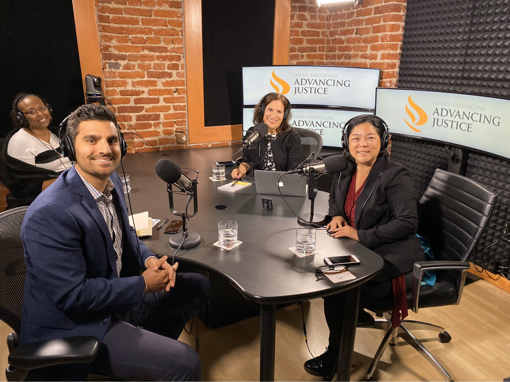 ALC staff members and reporters sit around a table with microphones. The group is recording a podcast interview about ALC's policy priorities.