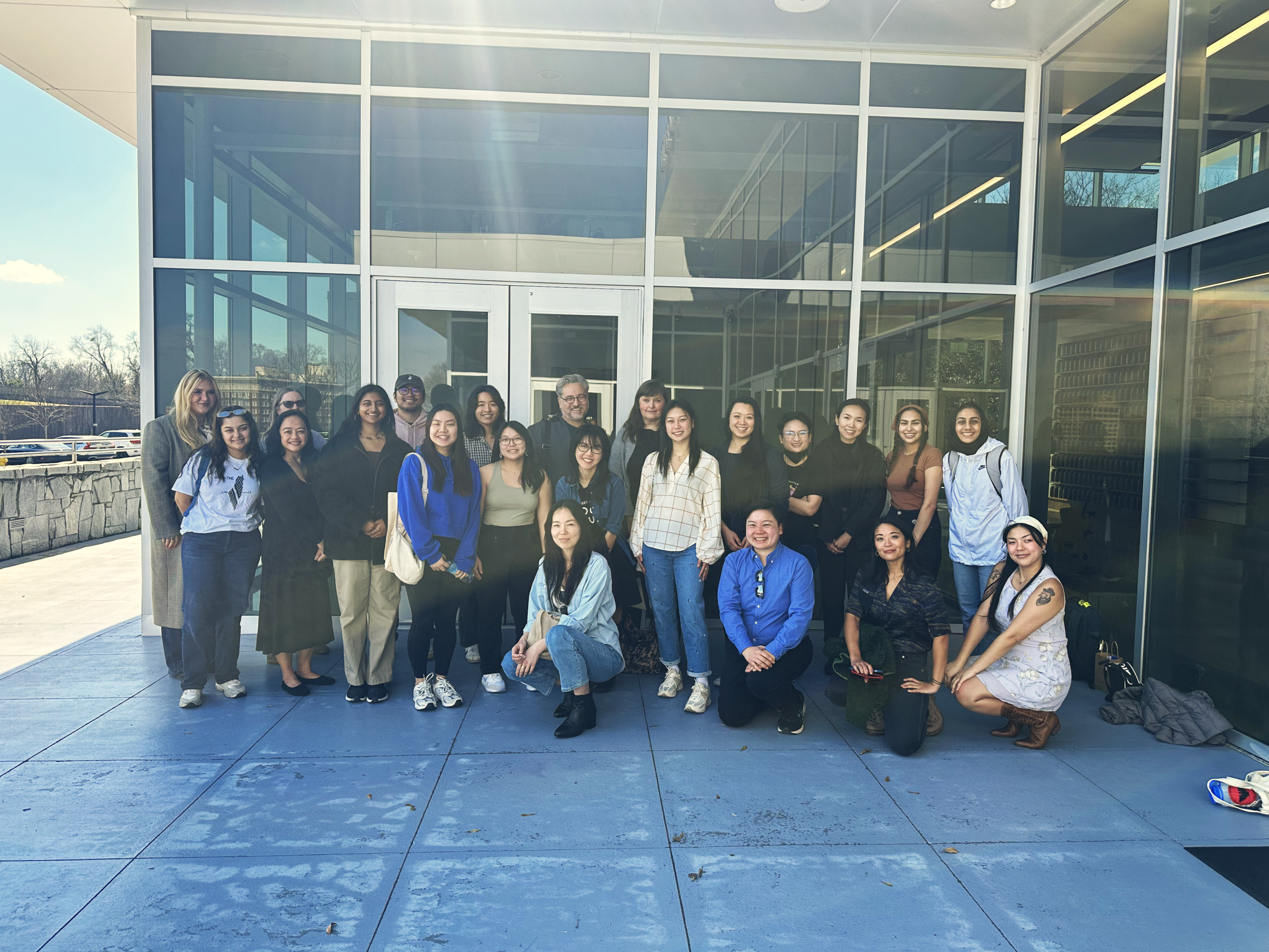 A large group photo is taken of 21 ALC staff members and one member of the Equal Justice Initiative staff member outside a museum.