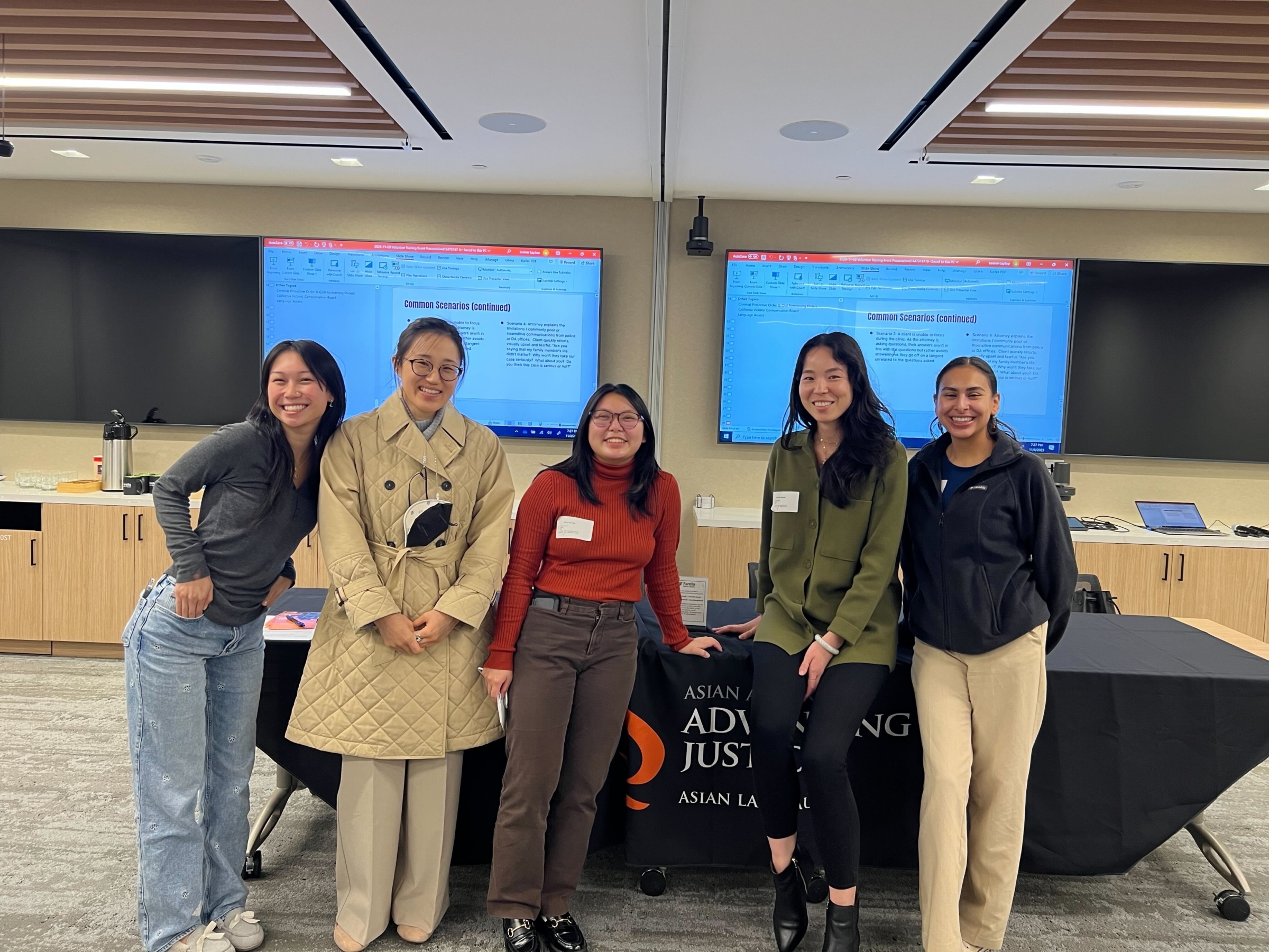 ALC staff pose in a group in front of an outreach table.