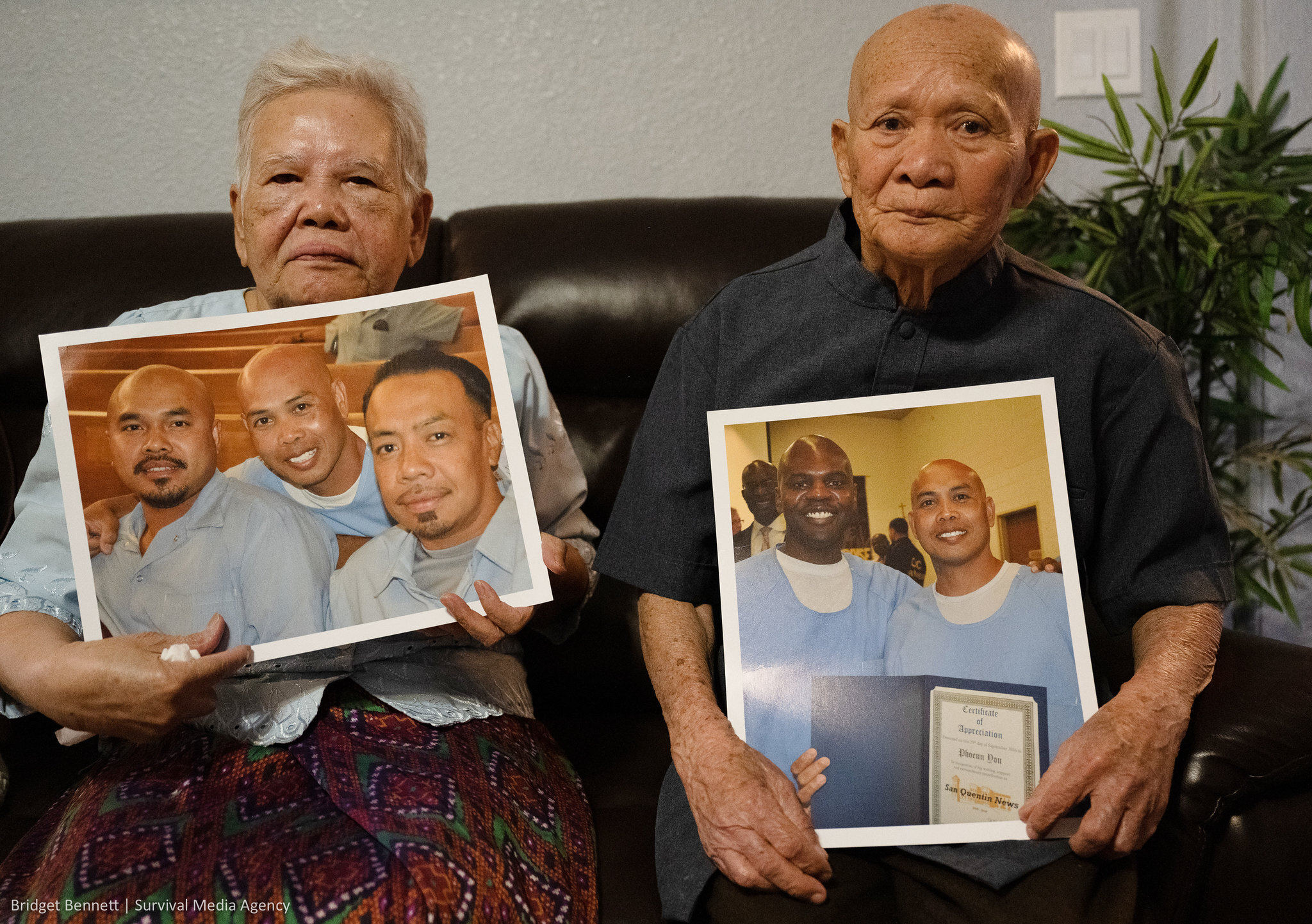 Phoeun You’s mother Yai ma Mony, and father Ket You hold photos of him.