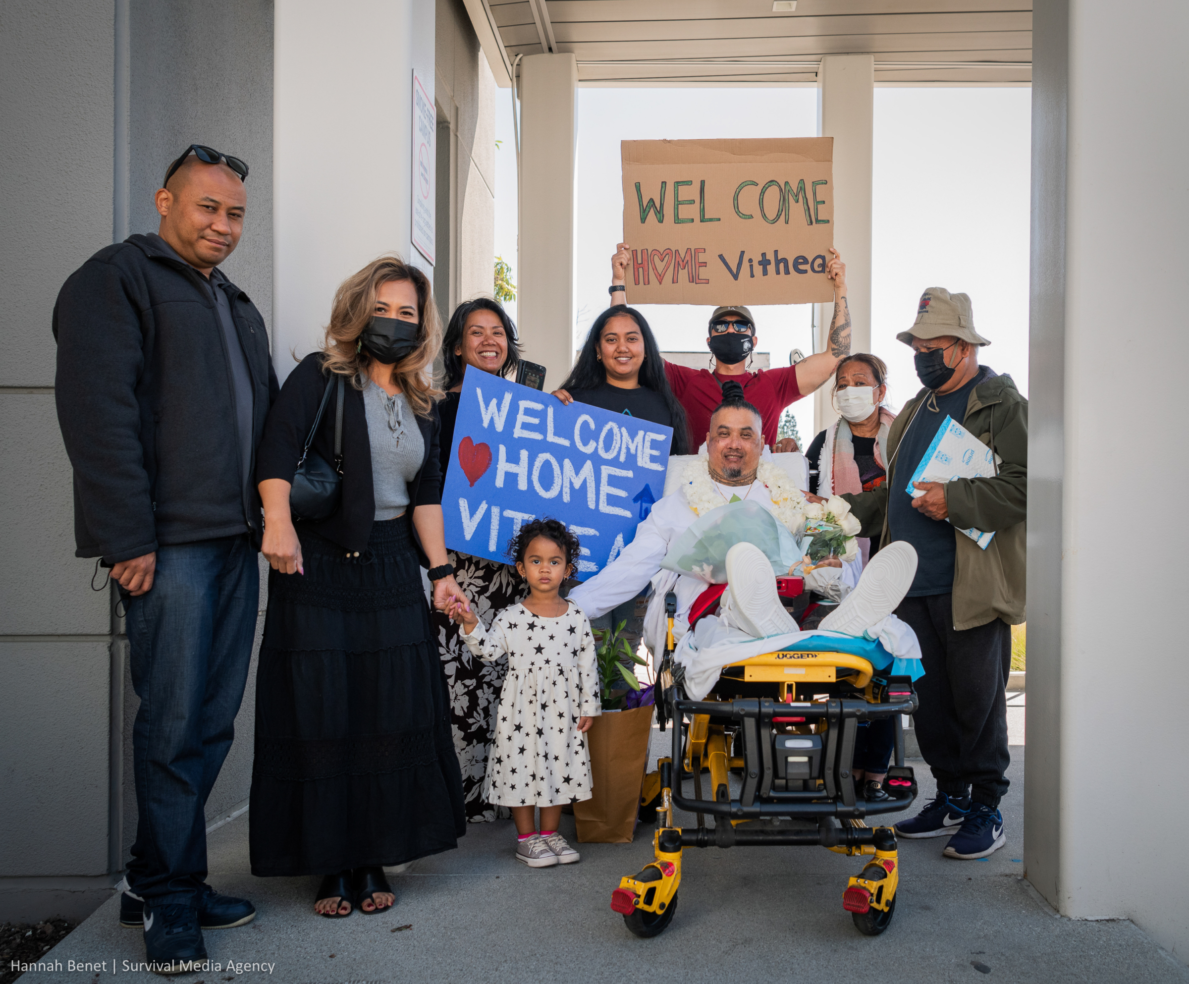 Vithea is surrounded by smiling family and community welcoming him home.