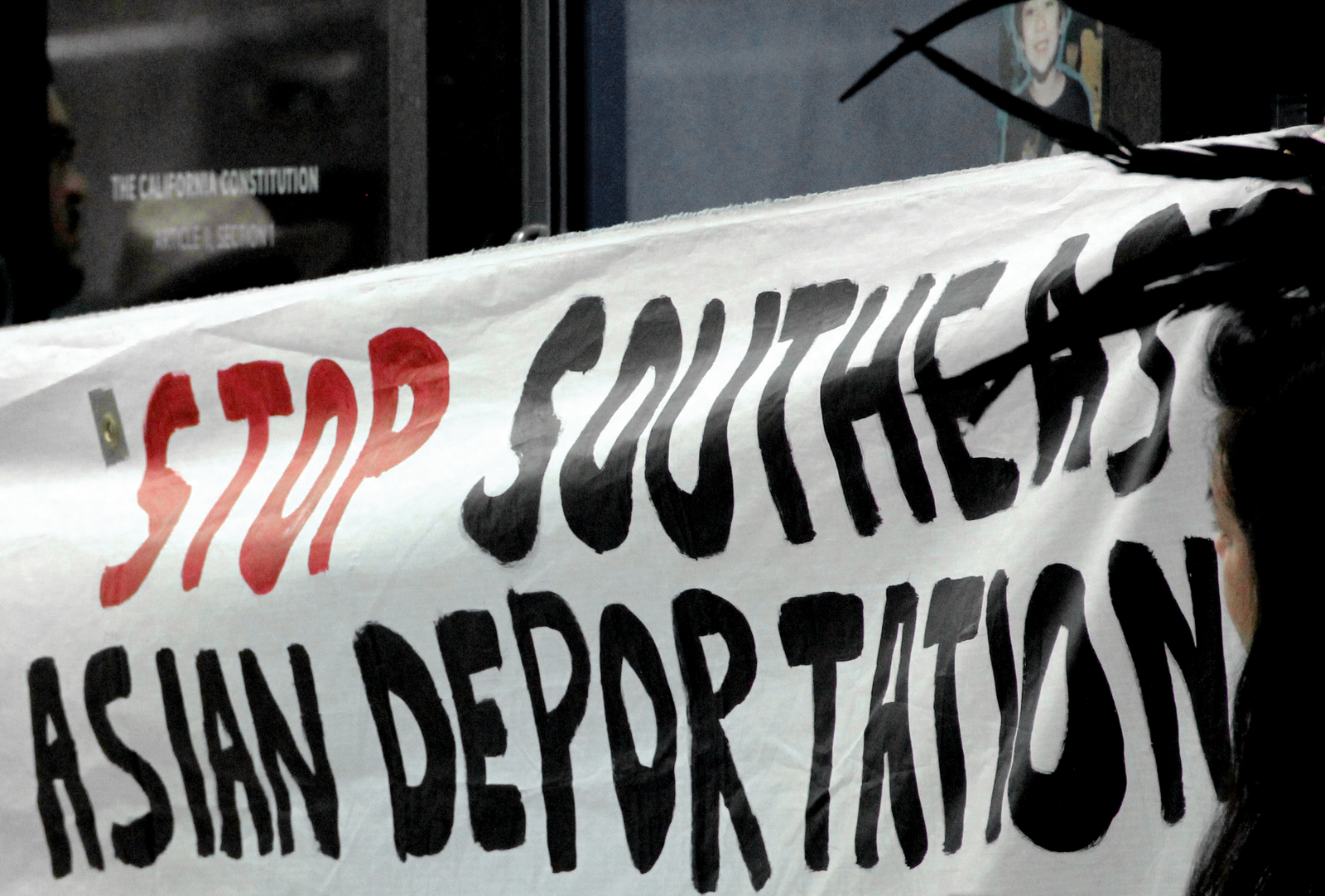 Banner reads "STOP SOUTHEAST ASIAN DEPORTATION" - the "stop" is in red