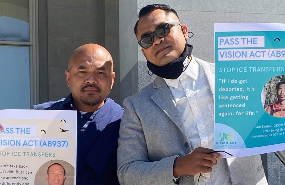 Chanthon Bun and Tith Ton holding up signs in support of the VISION Act.