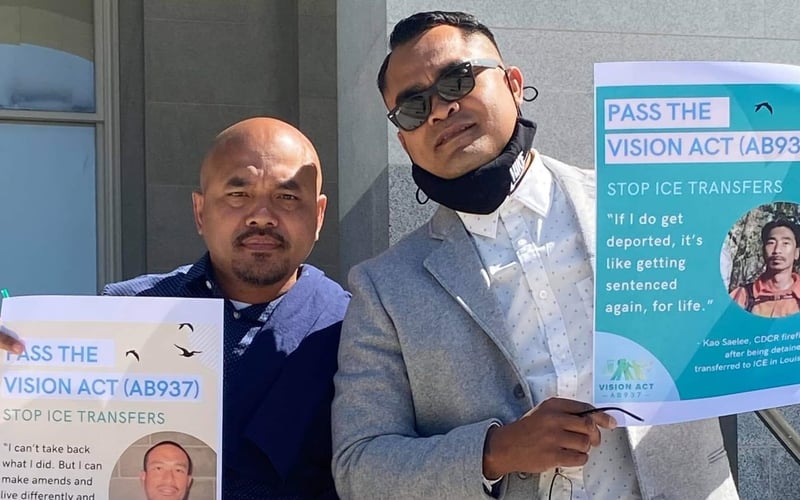 Chanthon Bun and Tith Ton holding up signs in support of the VISION Act.