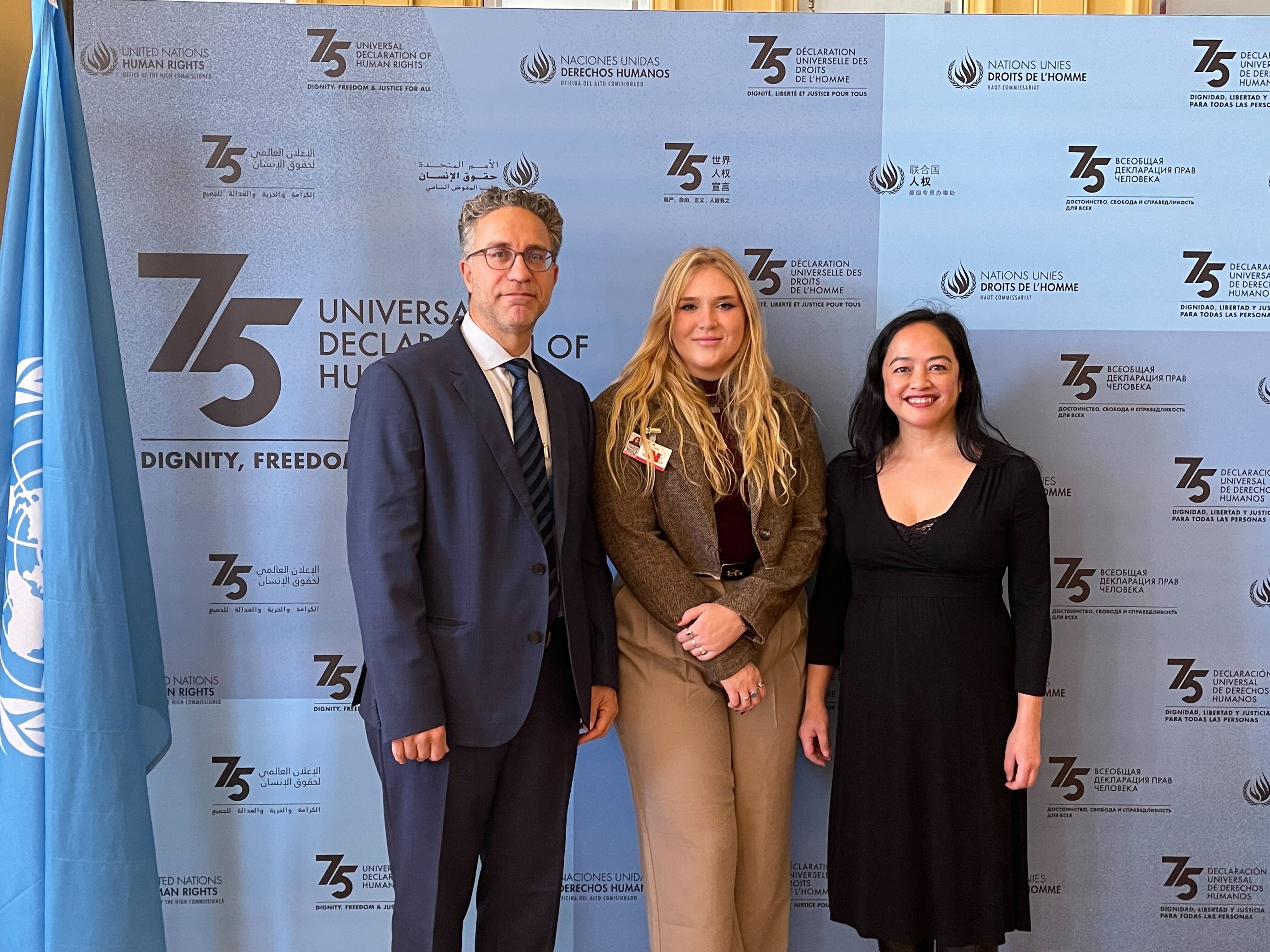 Jamil Dakwar, Human Rights Program Director at ACLU, Caroline Marks, NSCR Staff Attorney at ALC, and Gabriela Villareal, Policy Director at ALC pose for a picture in front of a UN Human Rights backdrop.