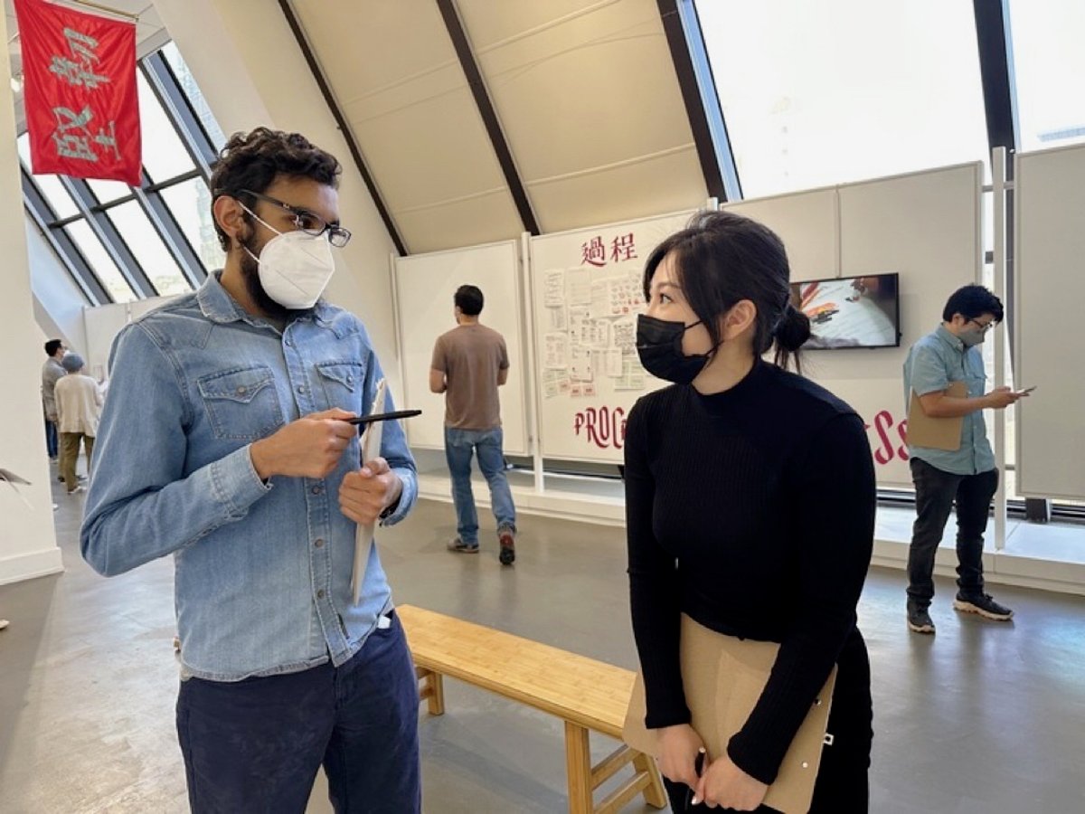 At a museum, Sallie and Adil speak to each other.