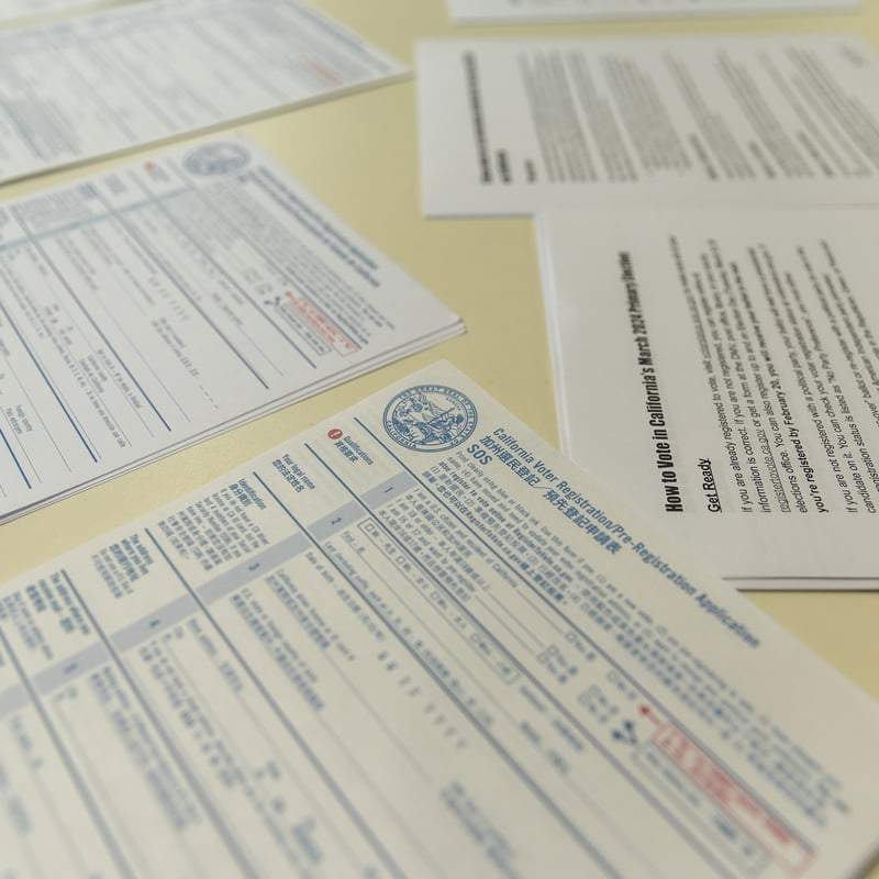 Voter registration forms and other materials spread out on a desk.
