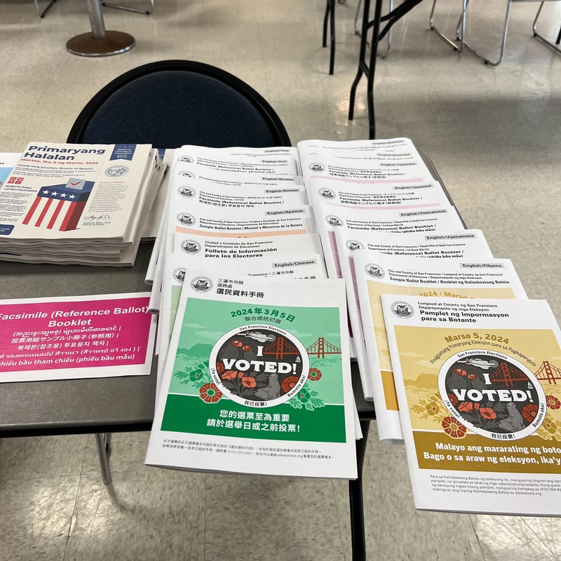 Reference ballots in Chinese and Filipino laid out on a table at a polling location in SF County.