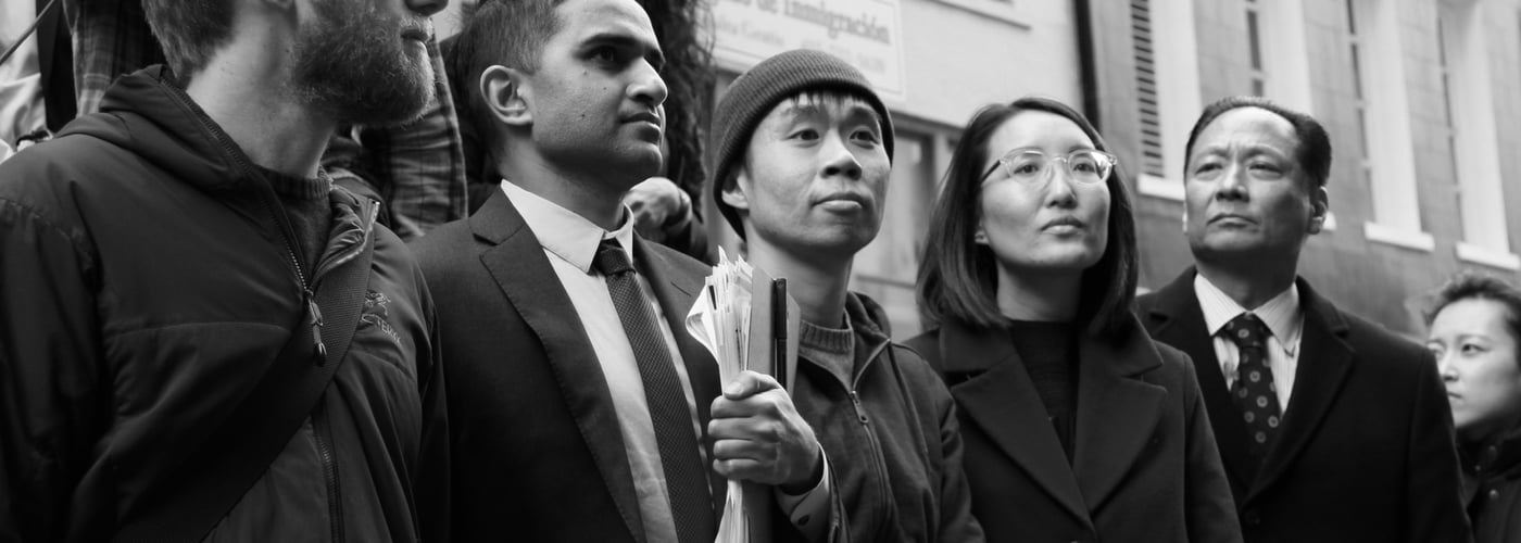 Black and white photo of 4 men and one woman outside standing in a row looking up