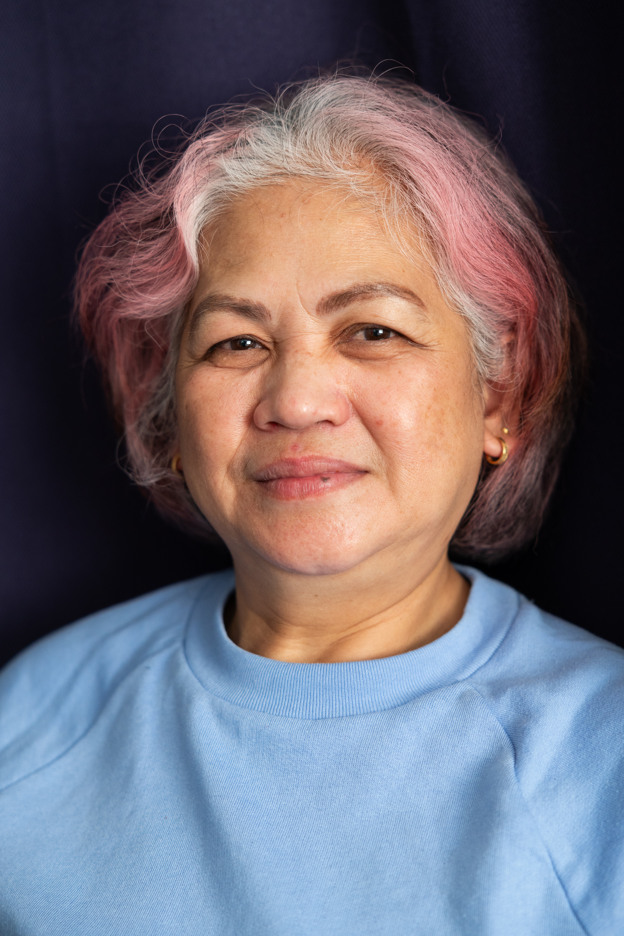 Photo: A woman with brightly colored hair smiles to the camera.