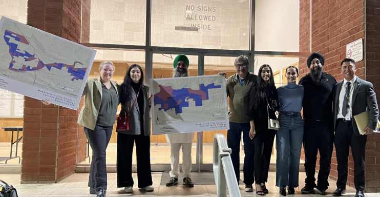 A group of Bakersfield residents hold up the maps that would keep their communities together.