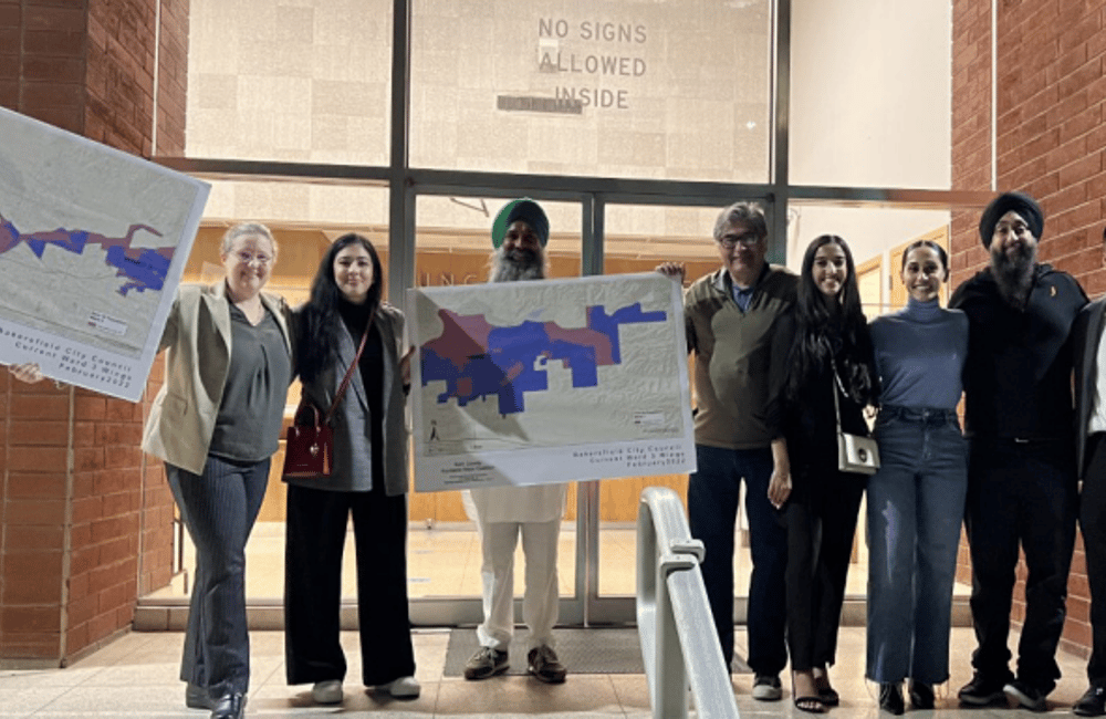 A group of Bakersfield residents hold up the maps that would keep their communities together.