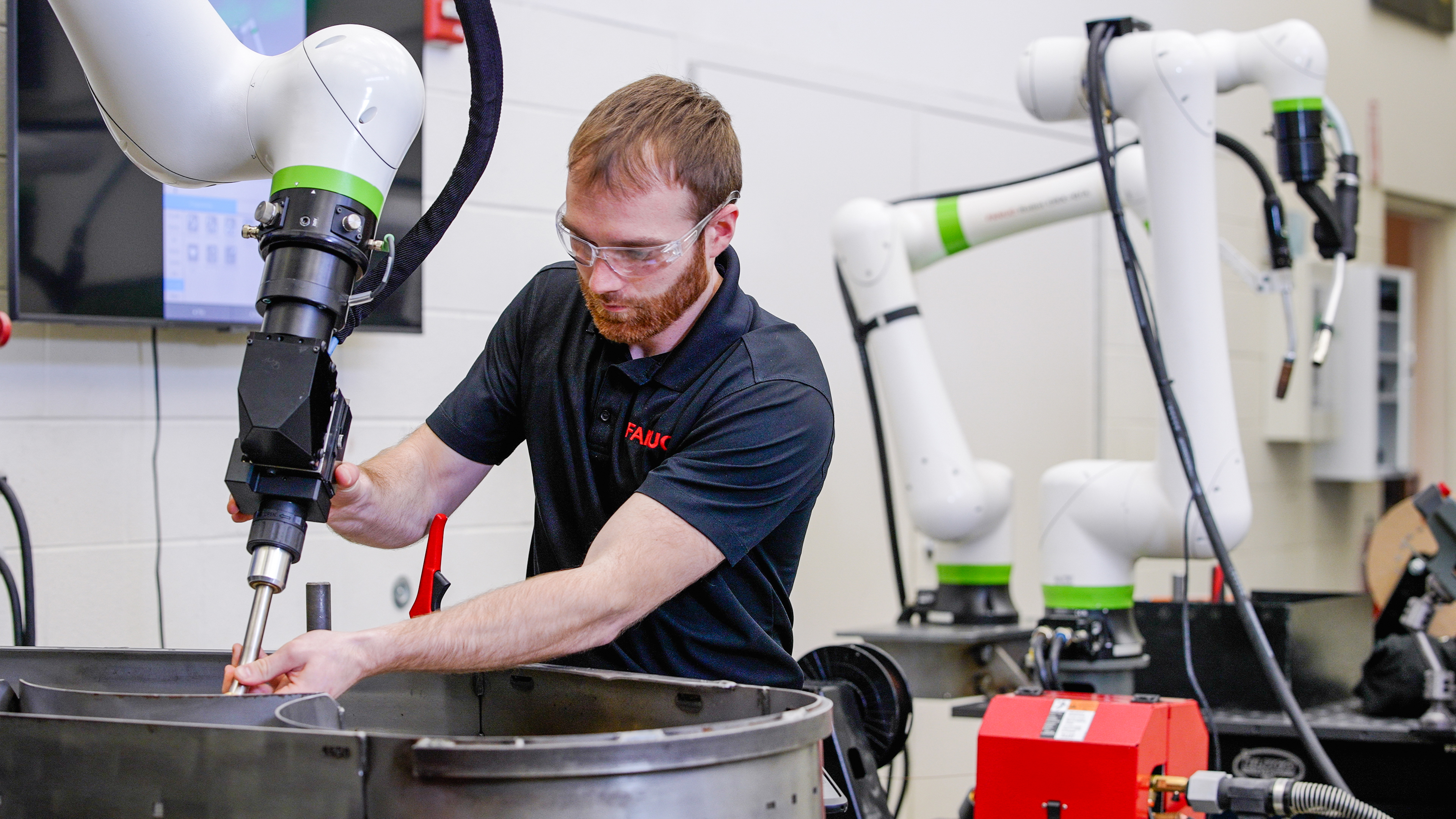 FANUC employee hand guiding CRX welding cobot