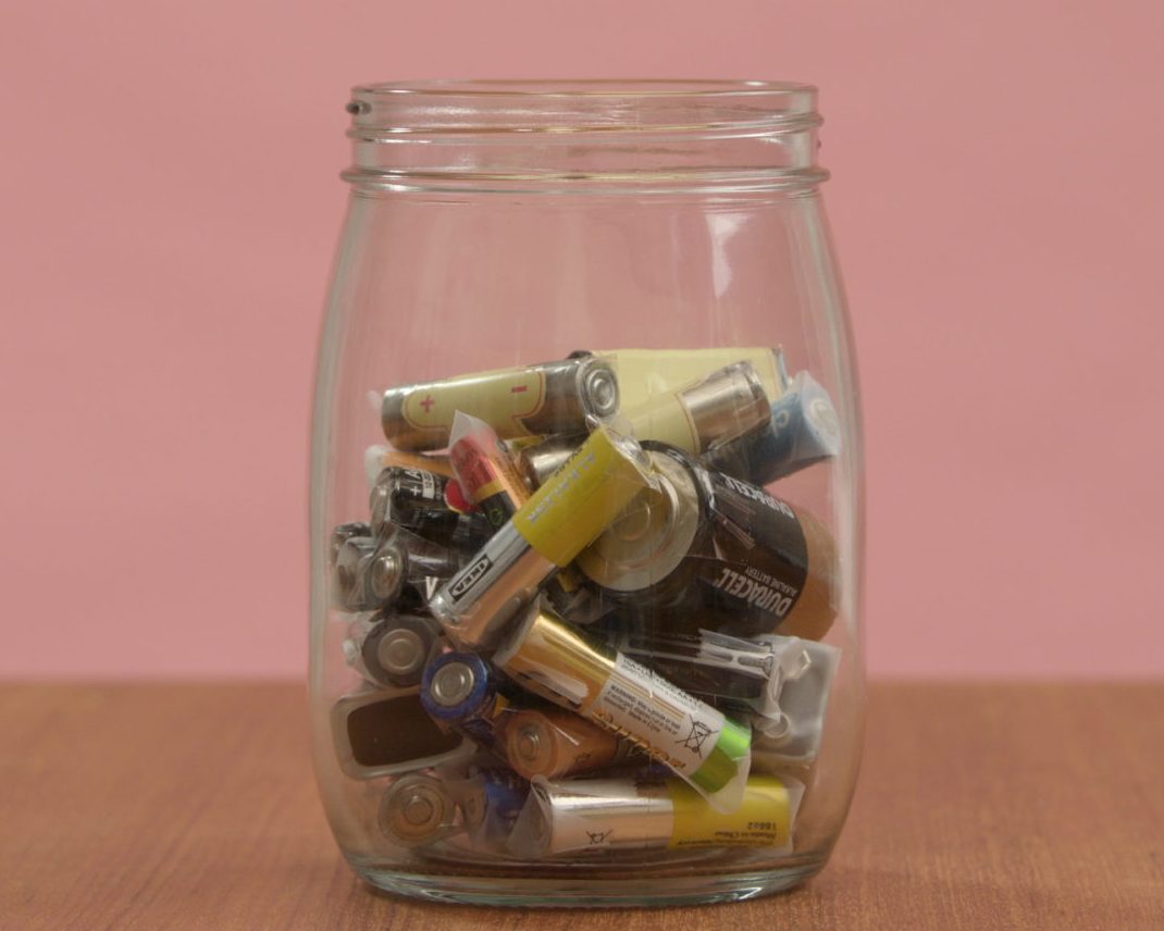 Bilde av brukte batterier i eit gjennomsiktig glass.