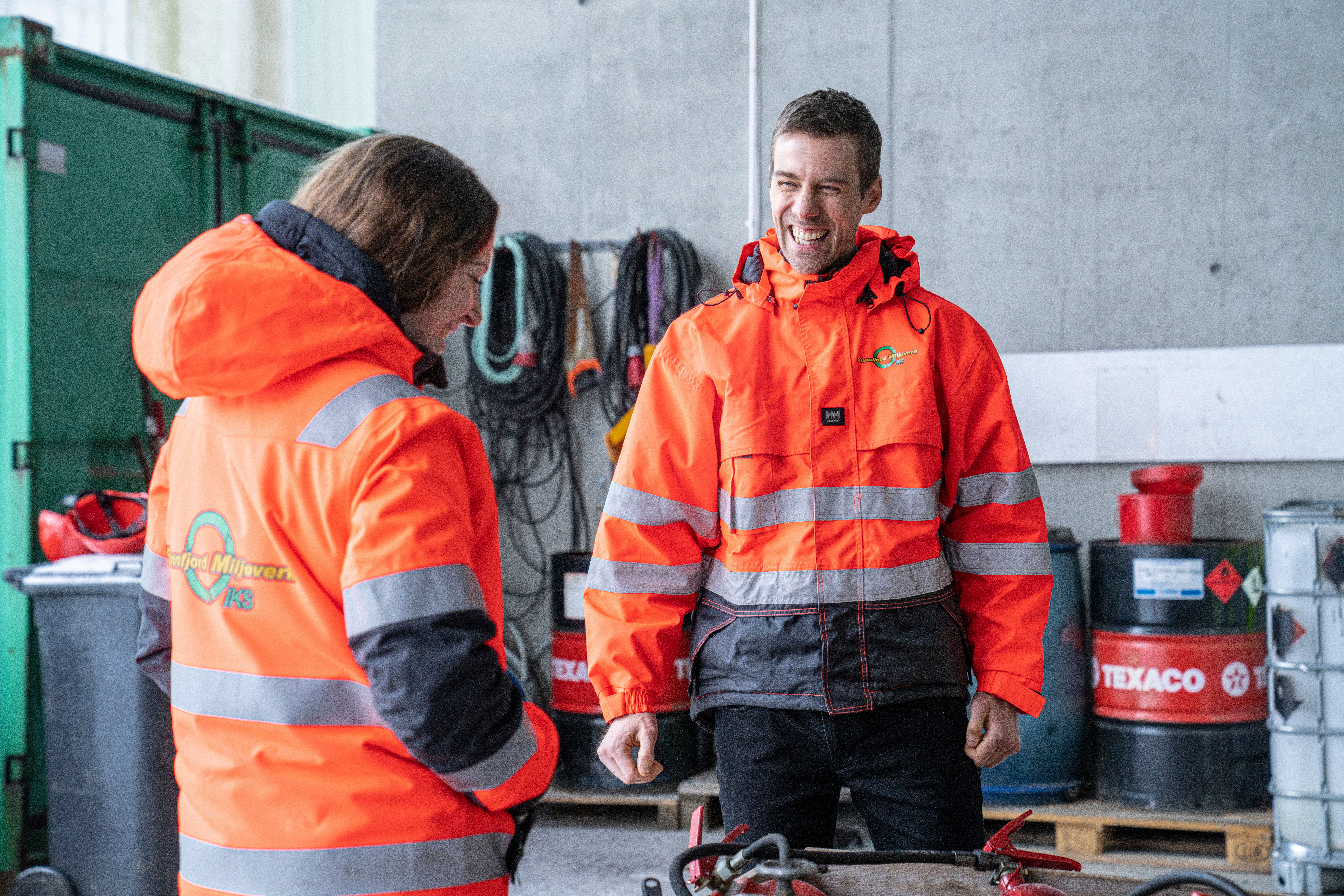 To gjenvinningsoperatørar i samtale med kvarandre.