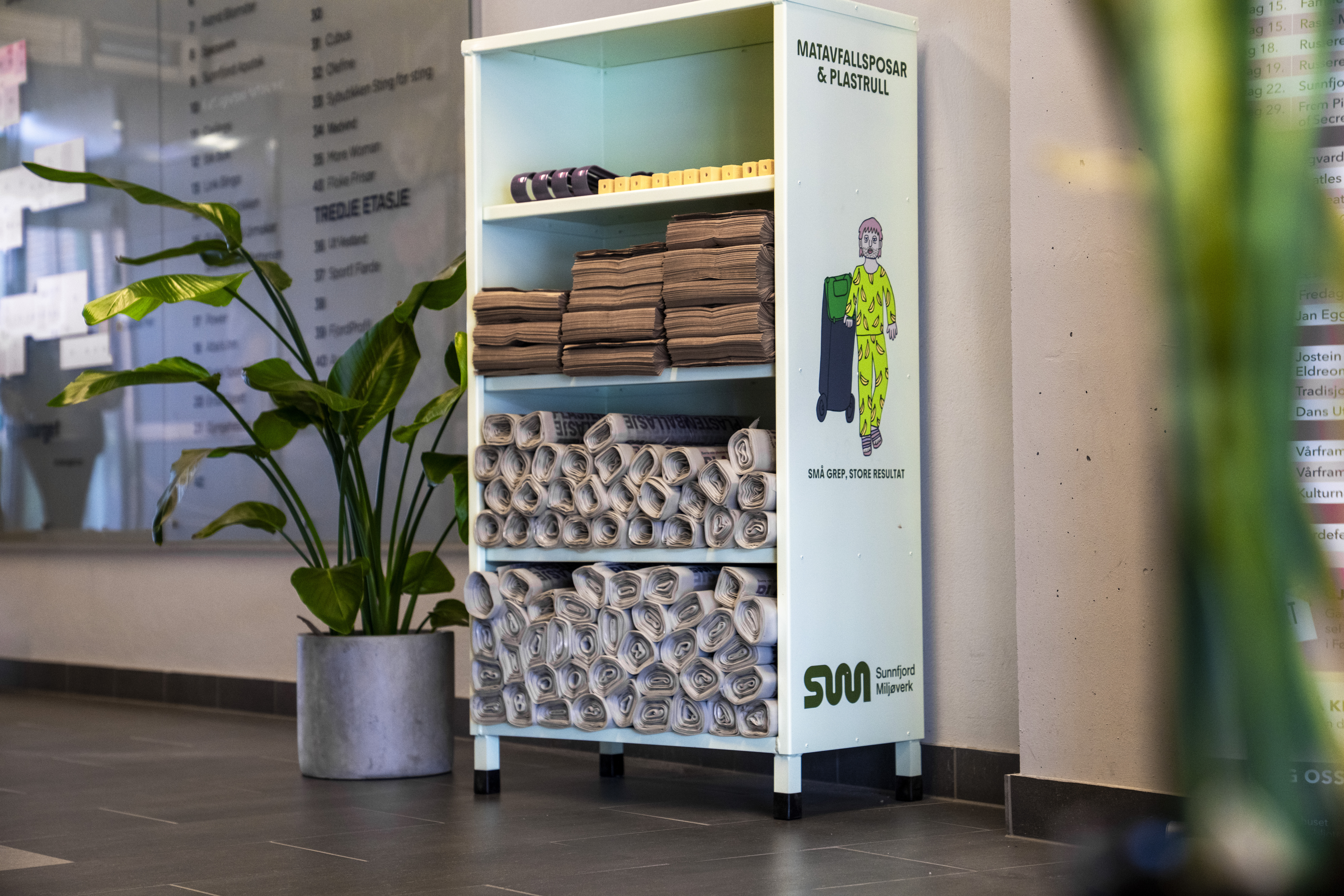 Hylle med matavfallsposar, plastsekkar og gule pinnar