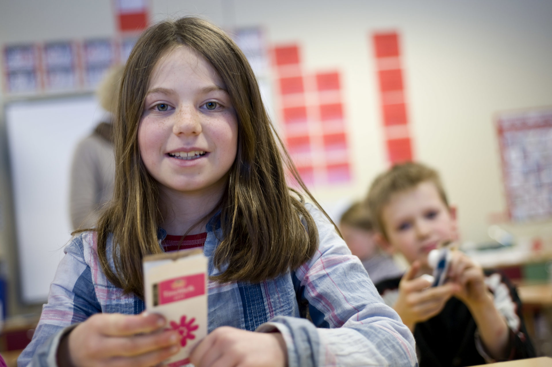 Skolejente som bretter en melkekartong