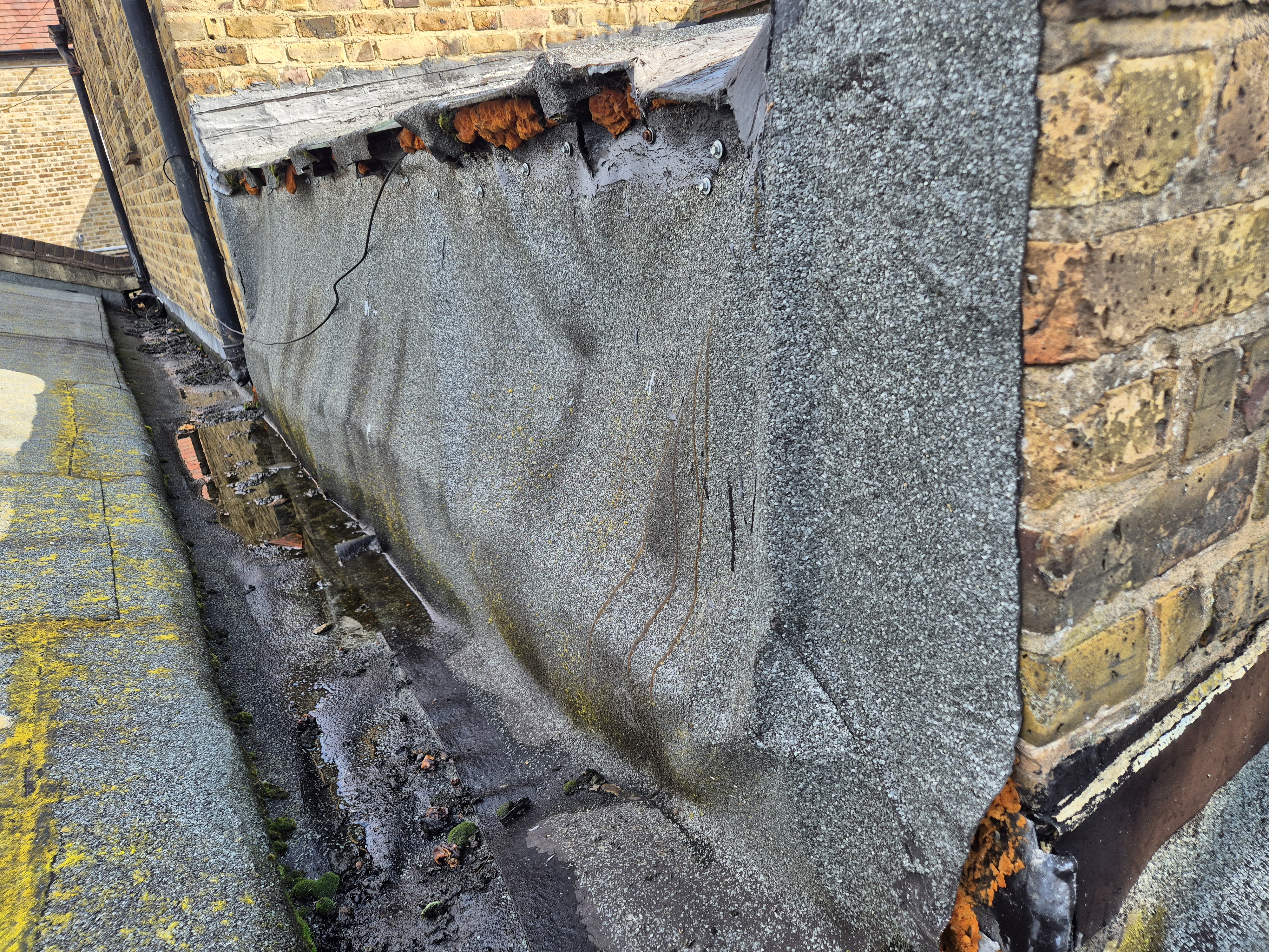 Grey concrete steps with rust stains and cracks against yellow brick wall, viewed from above.