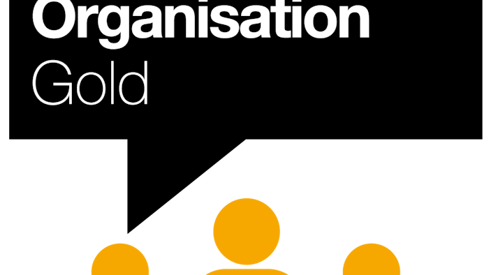 Black background with white text reading "Carbon Literate Organisation Gold" and orange silhouettes of five people below.