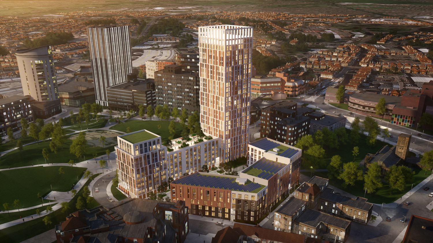 Aerial view of modern residential tower complex with glass and brick facades surrounded by urban neighbourhood and green spaces.