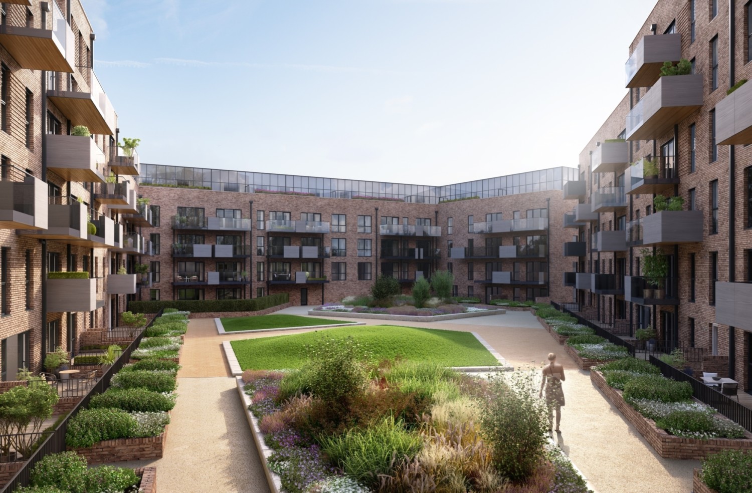 Modern apartment complex courtyard with brick buildings, landscaped gardens, central lawn area, and paved walkways under blue sky.