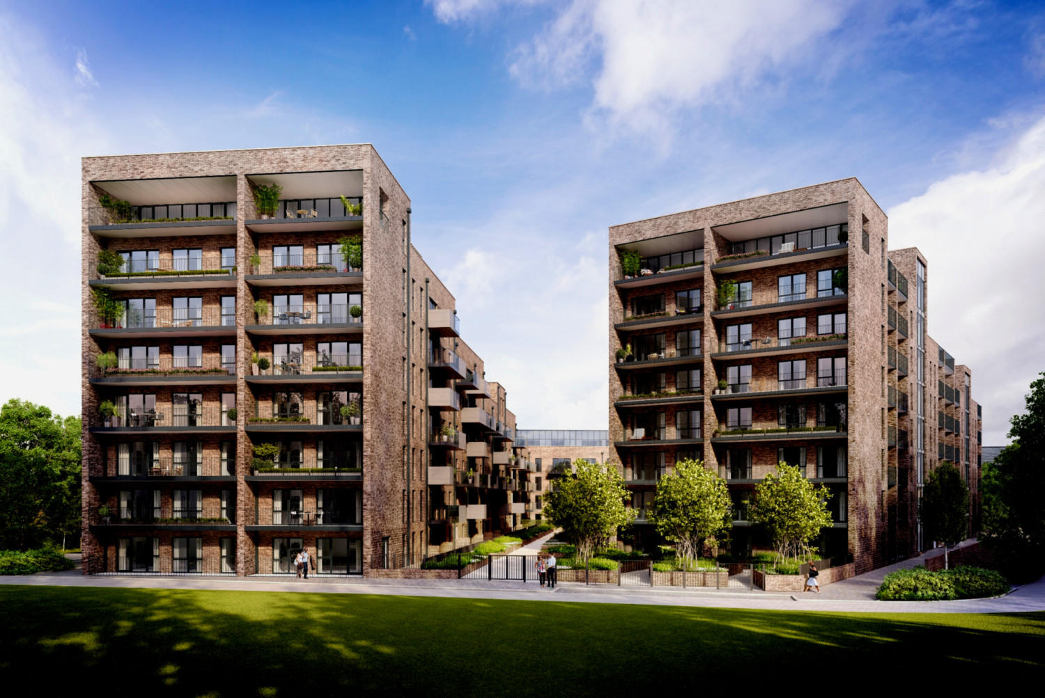 Modern brick apartment blocks with balconies and glass windows, surrounding green landscaped courtyard under blue sky with white clouds.