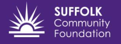 White text "SUFFOLK Community Foundation" on purple background with white stylised sun logo featuring radiating spikes above horizontal line.