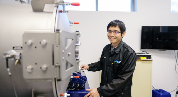 VPT employee standing in front of environmental testing machine