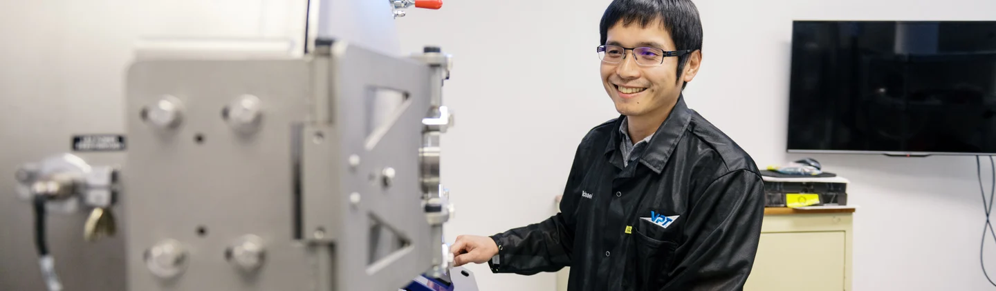 VPT employee standing in front of environmental testing machine