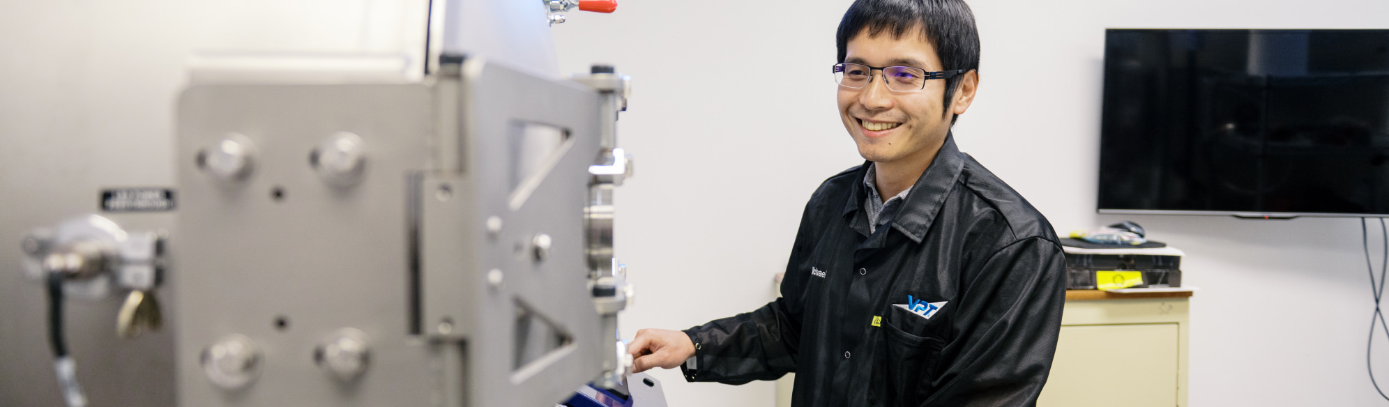 VPT employee standing in front of environmental testing machine