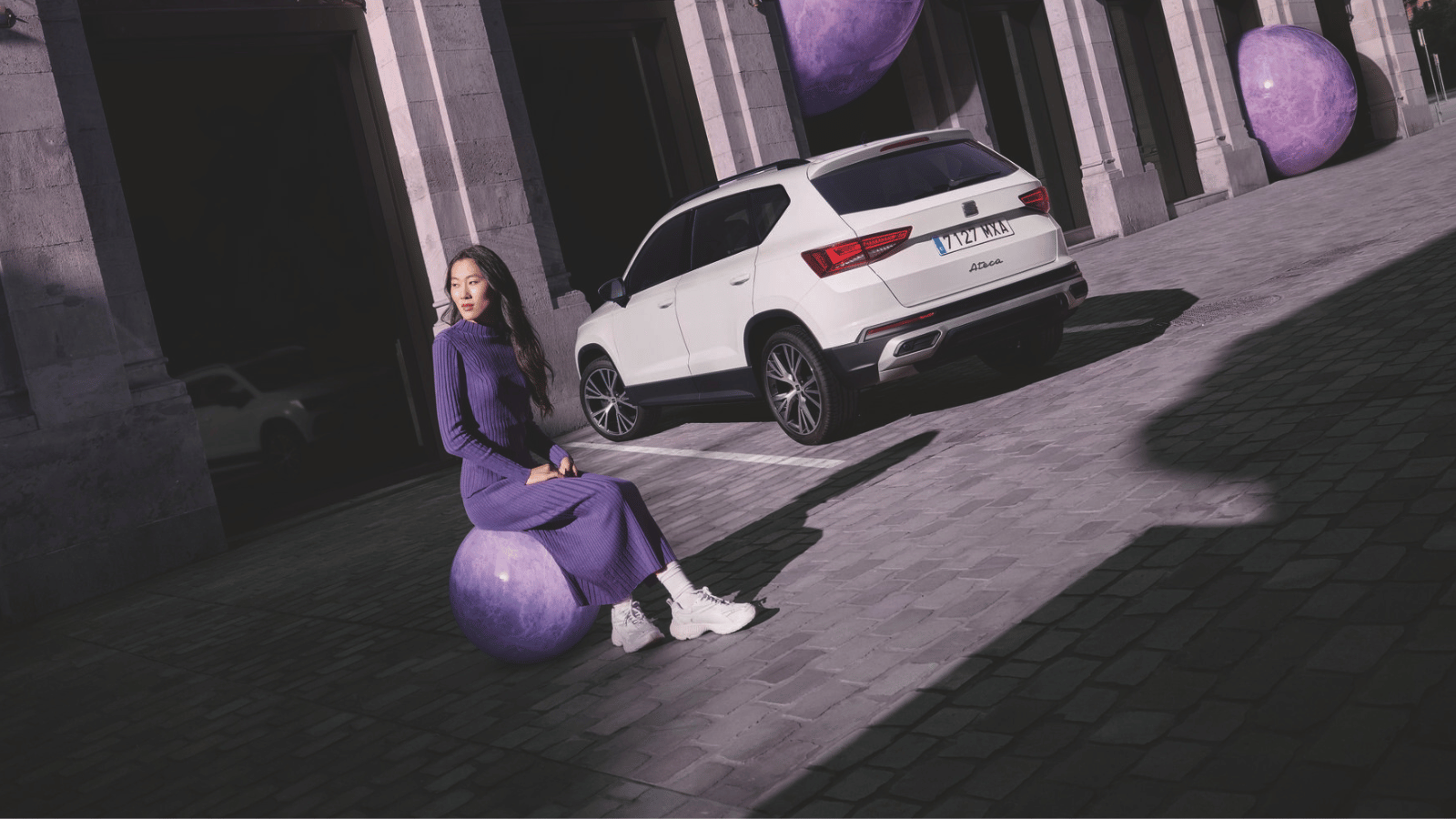 Vrouw met auto op de achtergrond en paarse kleuren