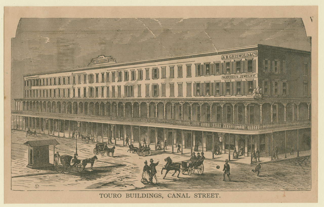 A vintage illustration of the Touro Buildings on Canal Street. It depicts a large, three-story building with a covered sidewalk, horse-drawn carriages, and pedestrians in front. Signs for A. B. Griswold & Co. and Watches & Jewelry are visible.