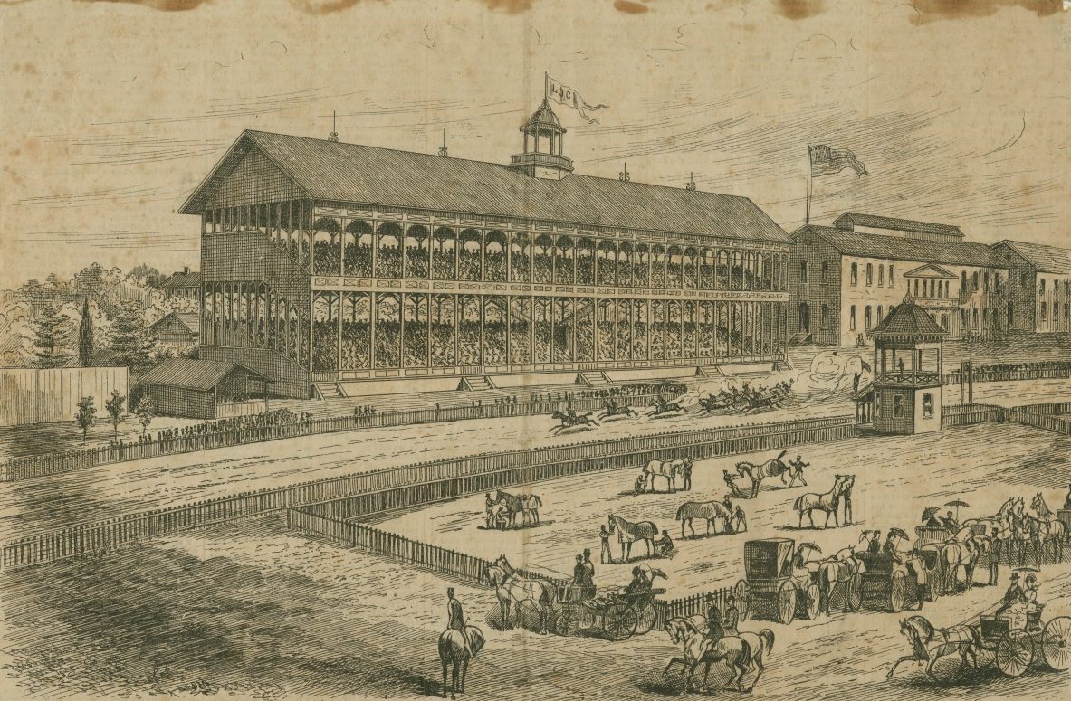 A vintage illustration depicts a bustling horse racing scene. A grandstand filled with spectators overlooks a dirt track where horses and jockeys race. In the foreground, horse-drawn carriages and people are gathered, evoking an active 19th-century atmosphere.