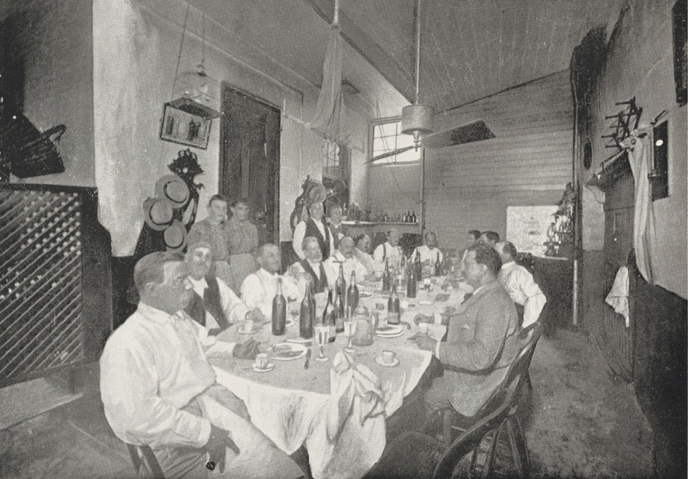 A group of men sit at the Begue's dining table.