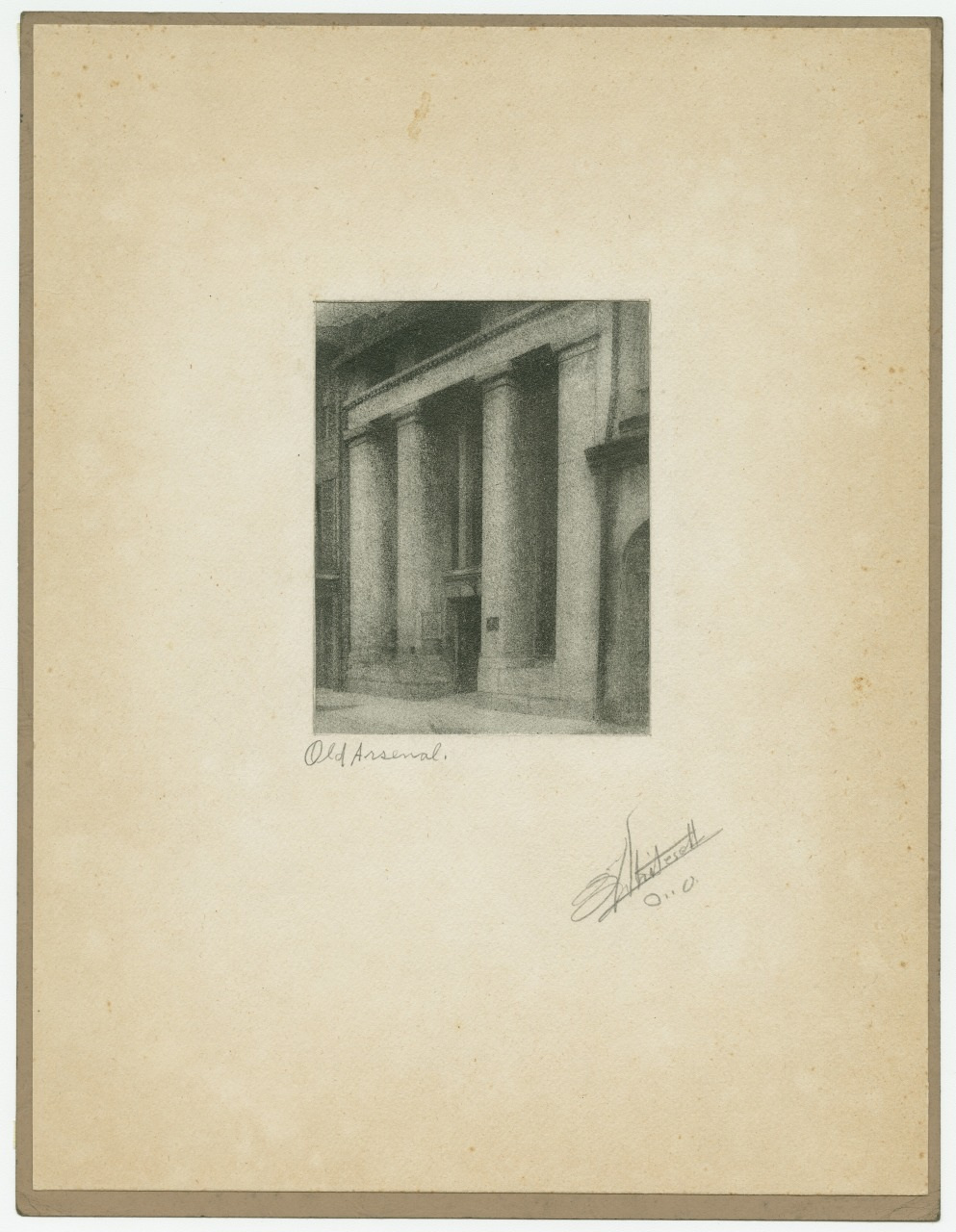 A sepia-toned image depicts the facade of a building with tall columns and an entrance in the center. The artwork is surrounded by a broad light-colored border with handwritten text Old Arsenal and a signature at the bottom right.