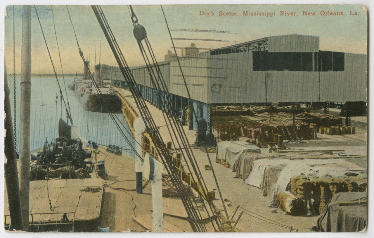 Vintage postcard depicting a dock scene on the Mississippi River in New Orleans, Louisiana. The image shows large ships docked, covered goods, and industrial buildings along the waterfront.