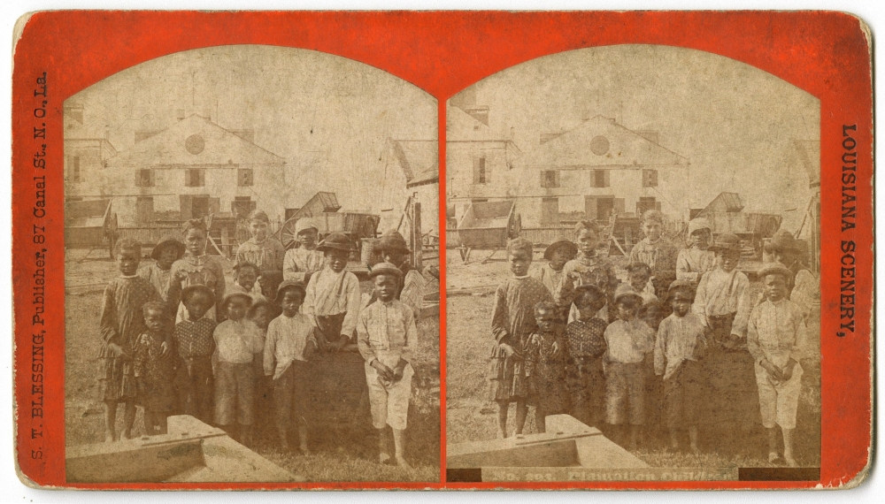 A sepia-toned stereograph image titled Louisiana Scenery showing a group of children and adults, some holding hats, standing in front of wooden buildings and a wagon. The scene appears to depict a plantation setting.