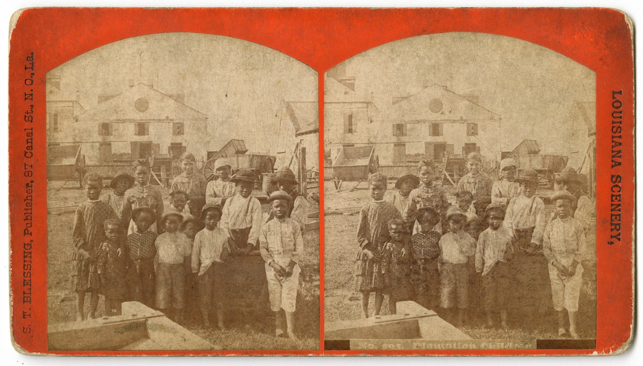 A vintage sepia-toned stereograph image depicts a group of people, including men, women, and children, standing outdoors on a plantation in front of buildings and a horse-drawn carriage. The image is labeled Louisiana Scenery.