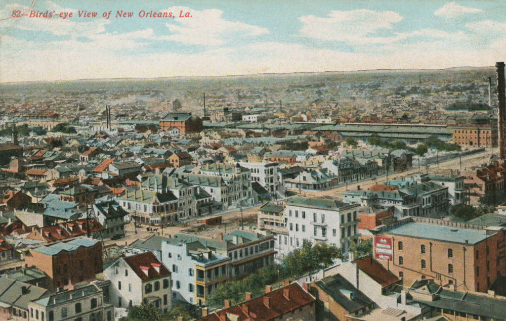A vintage postcard showing a birds-eye view of New Orleans, Louisiana. The image features numerous buildings, streets, and a distant skyline under a partly cloudy sky, creating a historic city landscape.