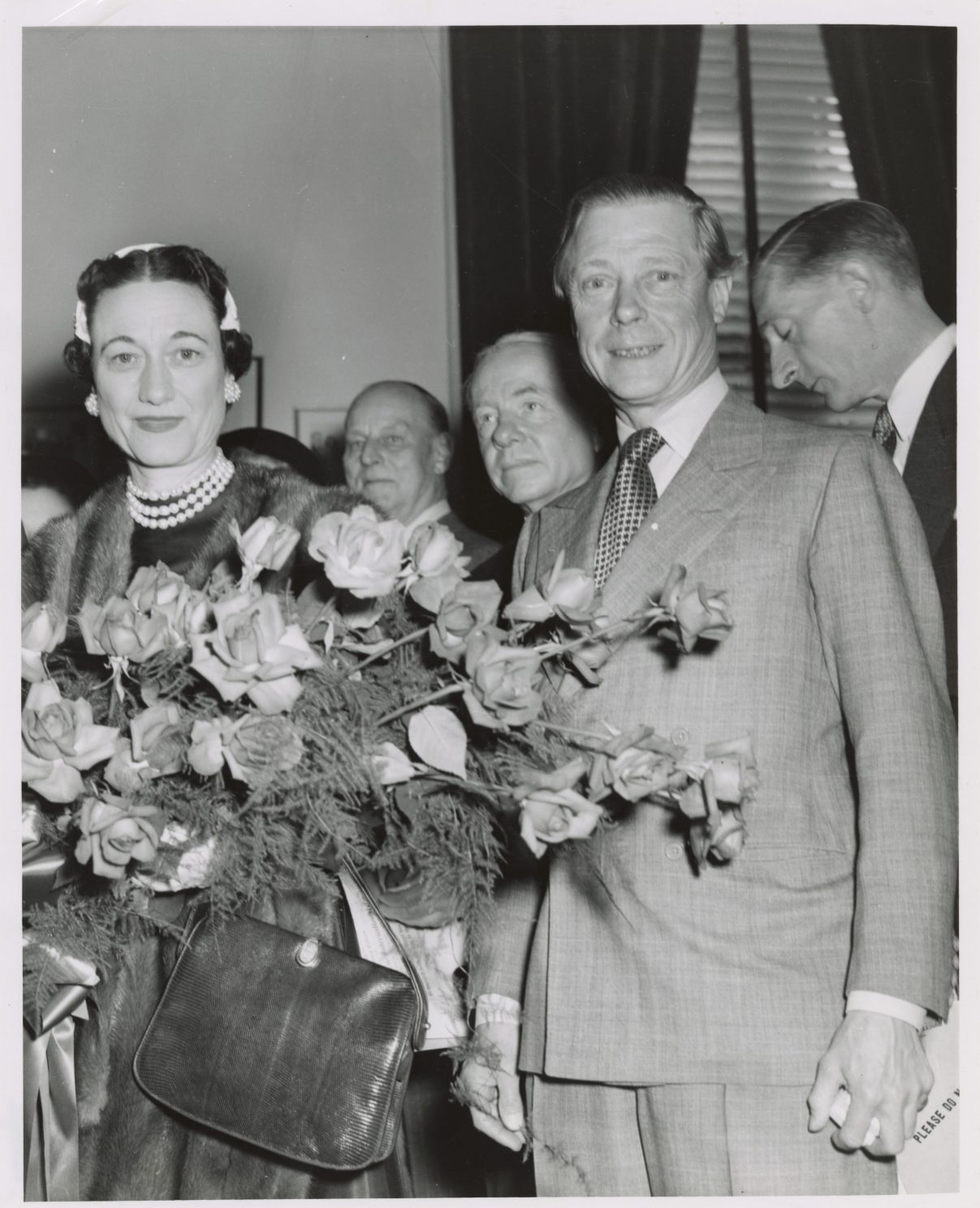 The Duchess of Windsor holds a bouquet standing next to the Duke.