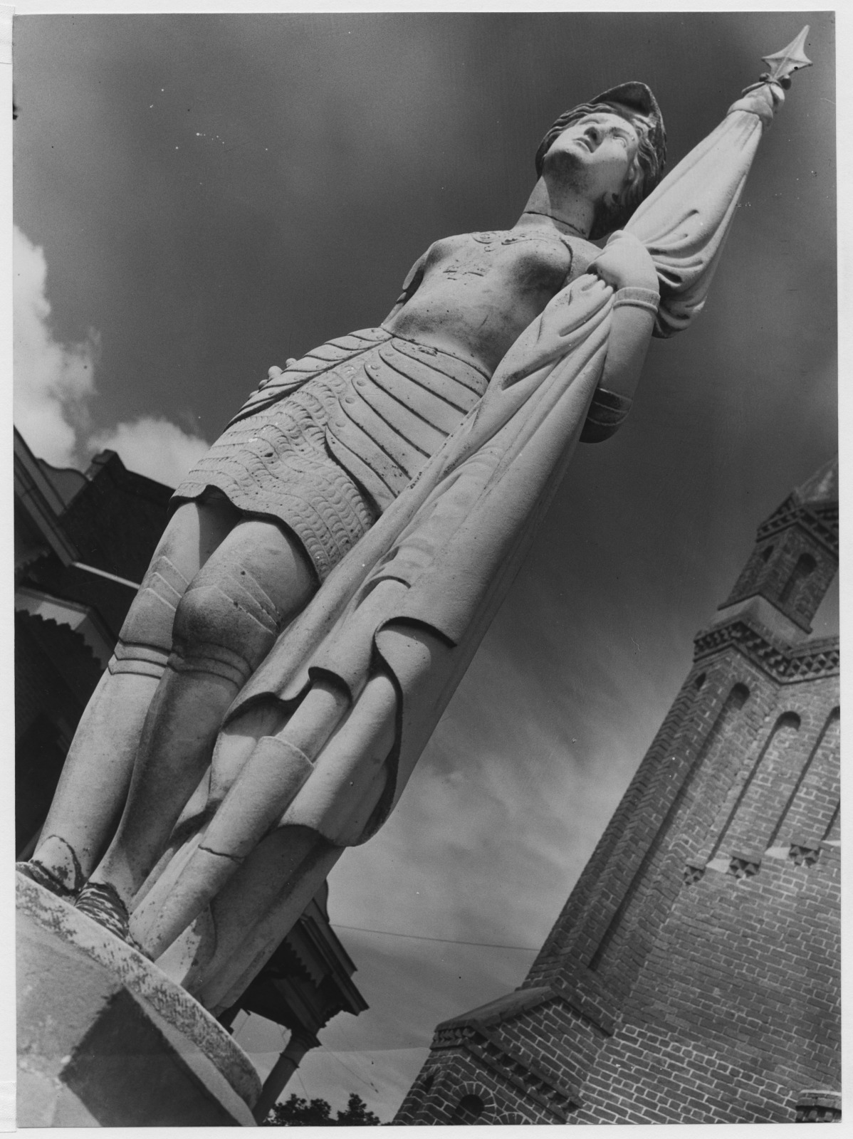 Black and white photo of a statue of Joan of Arc outside St. Michael the Archangel Catholic Church in Convent, Louisiana, between 1938 and 1974.