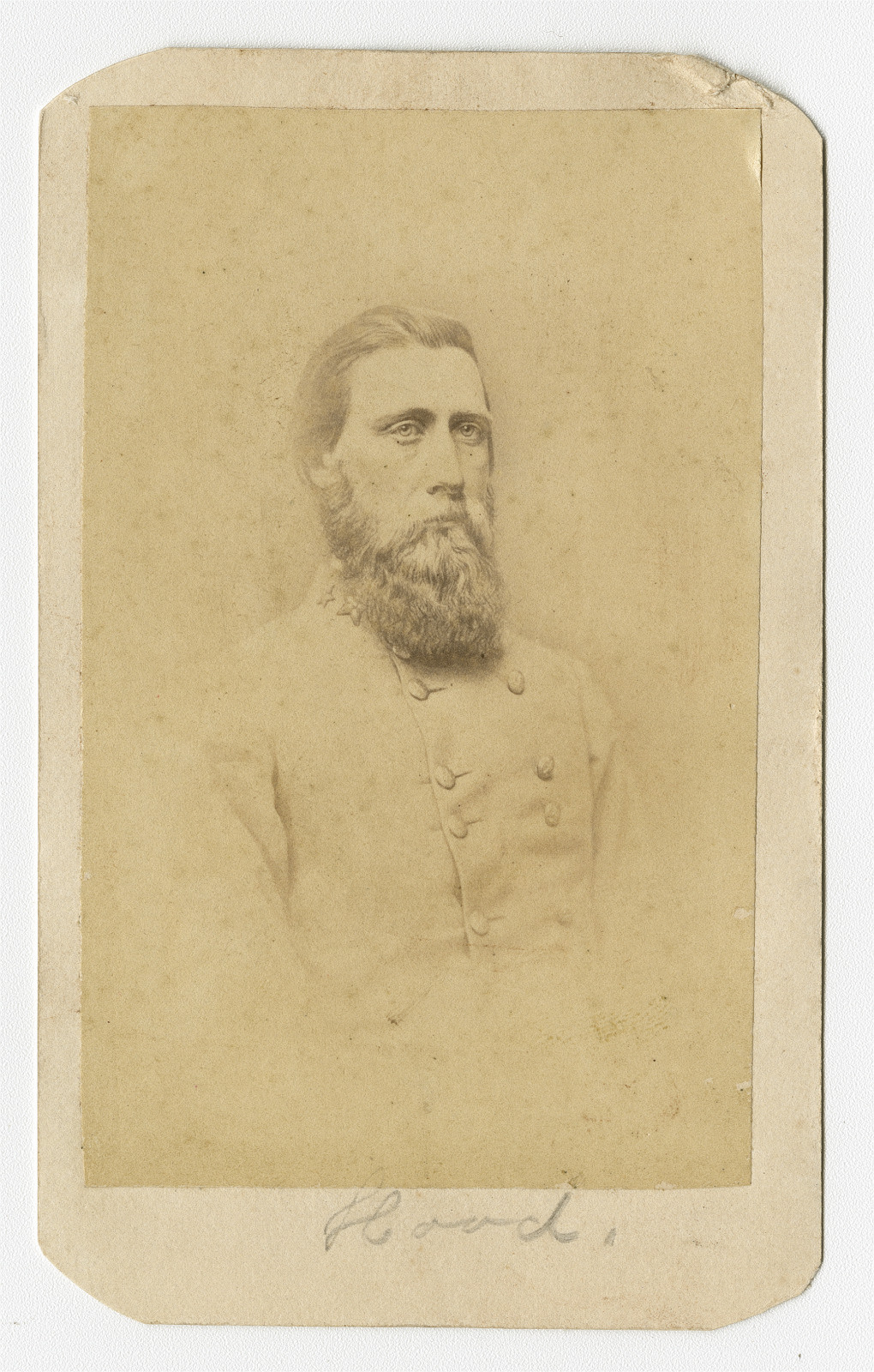 Sepia-toned portrait of a bearded man in a military uniform with buttons. The background is plain, and there is a handwritten text at the bottom on a slightly worn card.