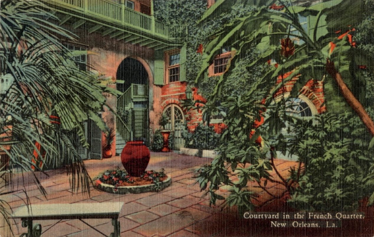 A vintage postcard depicts a courtyard in the French Quarter, New Orleans, Louisiana. The space features lush greenery, brick walls, and a prominent red vase on a tiled courtyard floor. Arched windows and a staircase add to the historic ambiance.