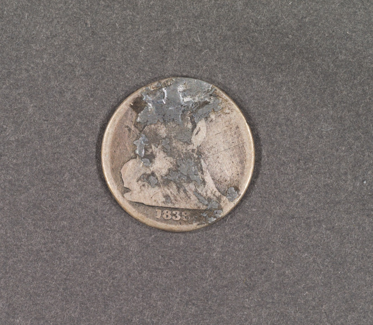 A weathered coin from 1833 with significant wear, making the design details hard to distinguish, set against a textured gray background.