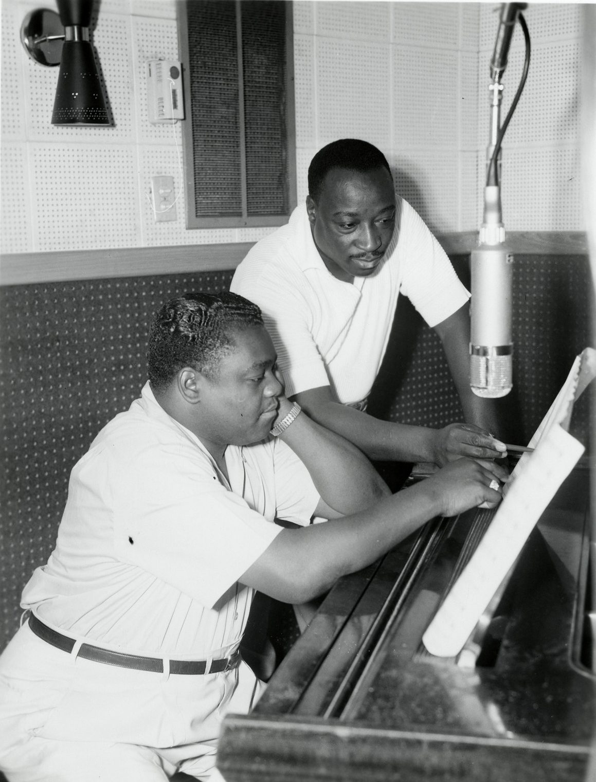 Antoine “Fats” Domino and Dave Bartholomew at a piano in a recording studio, 1957.