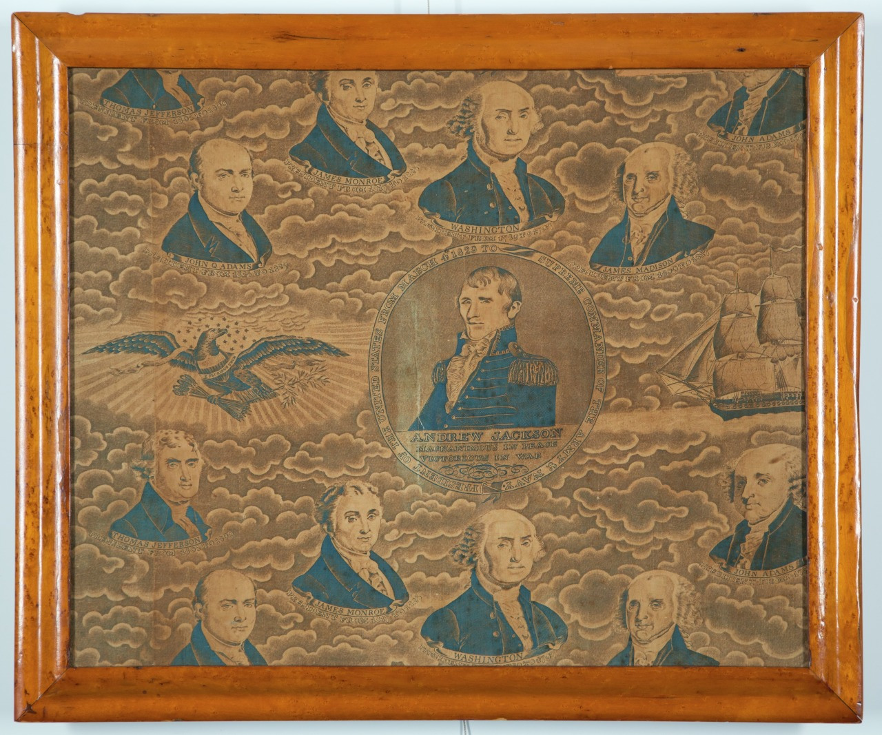 A framed vintage illustration depicting multiple portraits of men in blue attire surrounded by clouds. An eagle and a ship are also featured. Central portrait is larger, emphasizing importance. The frame is a polished light wood.