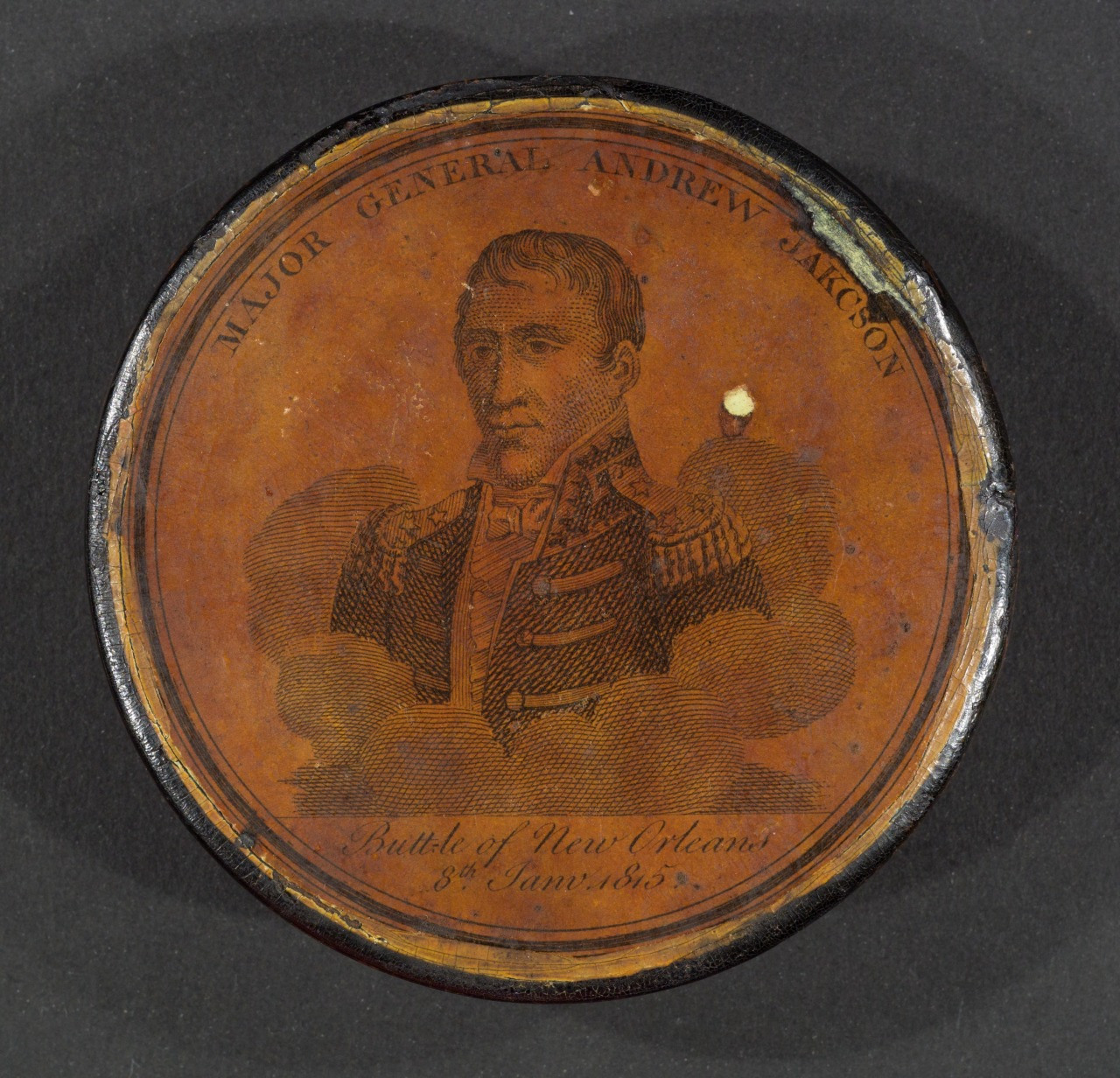An old circular portrait of Major General Andrew Jackson on a brown background. The text includes his name and mentions the Battle of New Orleans, dated 8th January 1815. The outer rim is worn and slightly damaged.