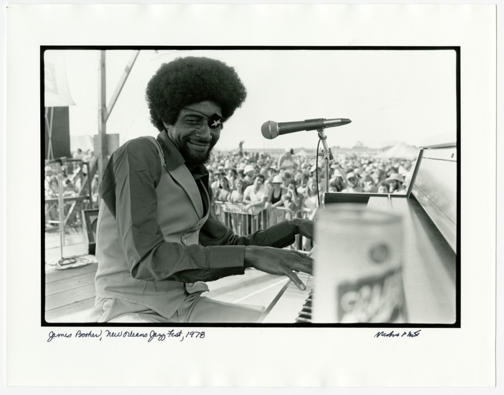 A musician with an afro plays piano on stage at an outdoor festival. A crowd watches in the background. A microphone is positioned near the piano, and a can is visible in the foreground. The image is black and white, dated 1978.