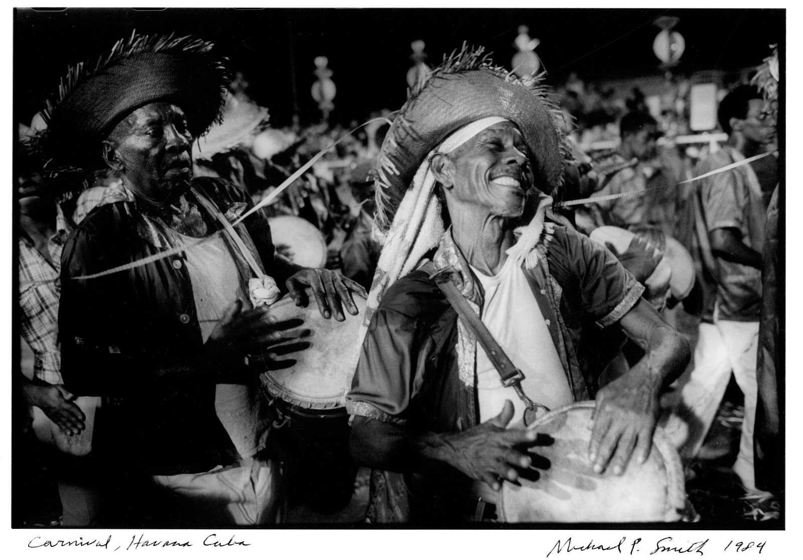 View of a what appears to be a night time procession showing a group of percussionists, mostly drummers.
