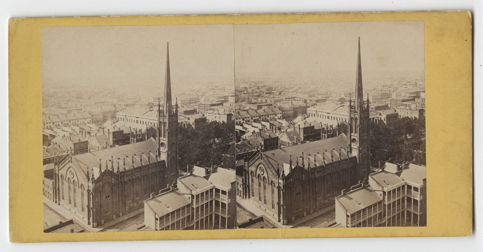 A sepia-toned stereoscopic image of a large church with a tall spire, surrounded by tightly packed buildings in a cityscape. The photo captures a panoramic view, reflecting architecture from a bygone era.